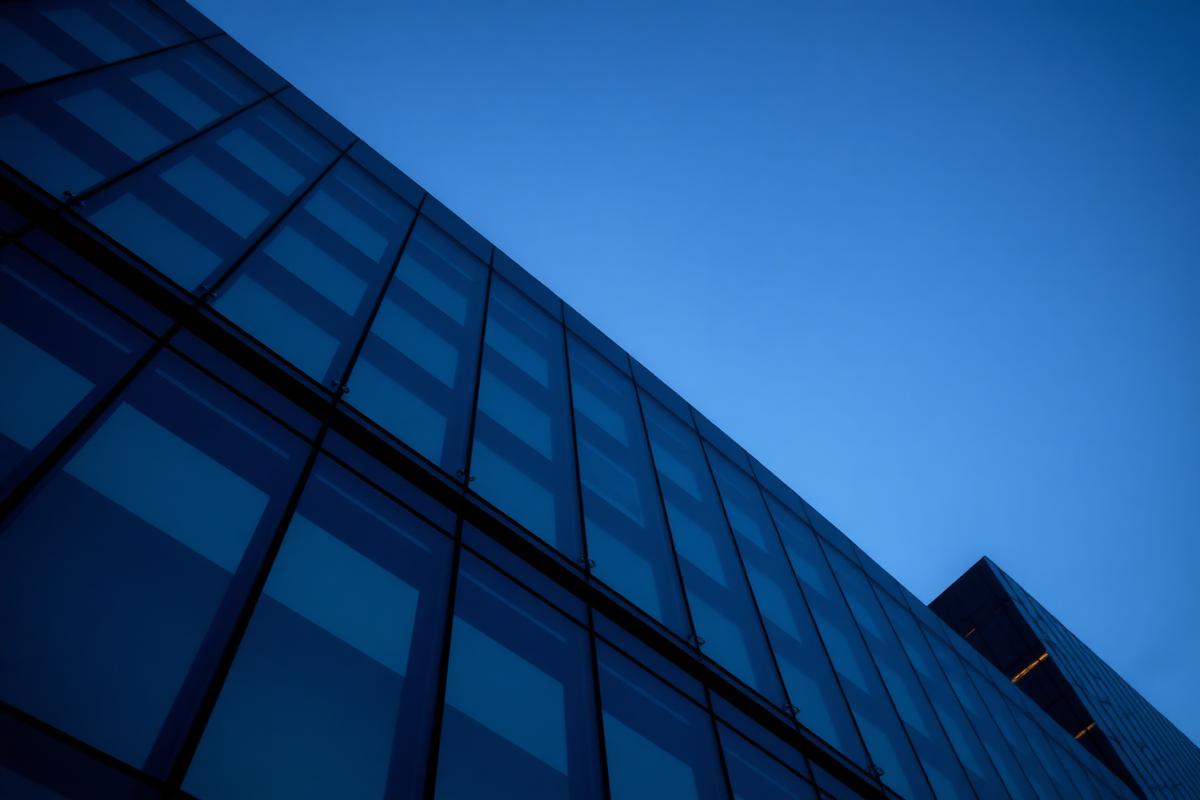 Fachada corporativa moderna al atardecer, símbolo de inversión y crecimiento